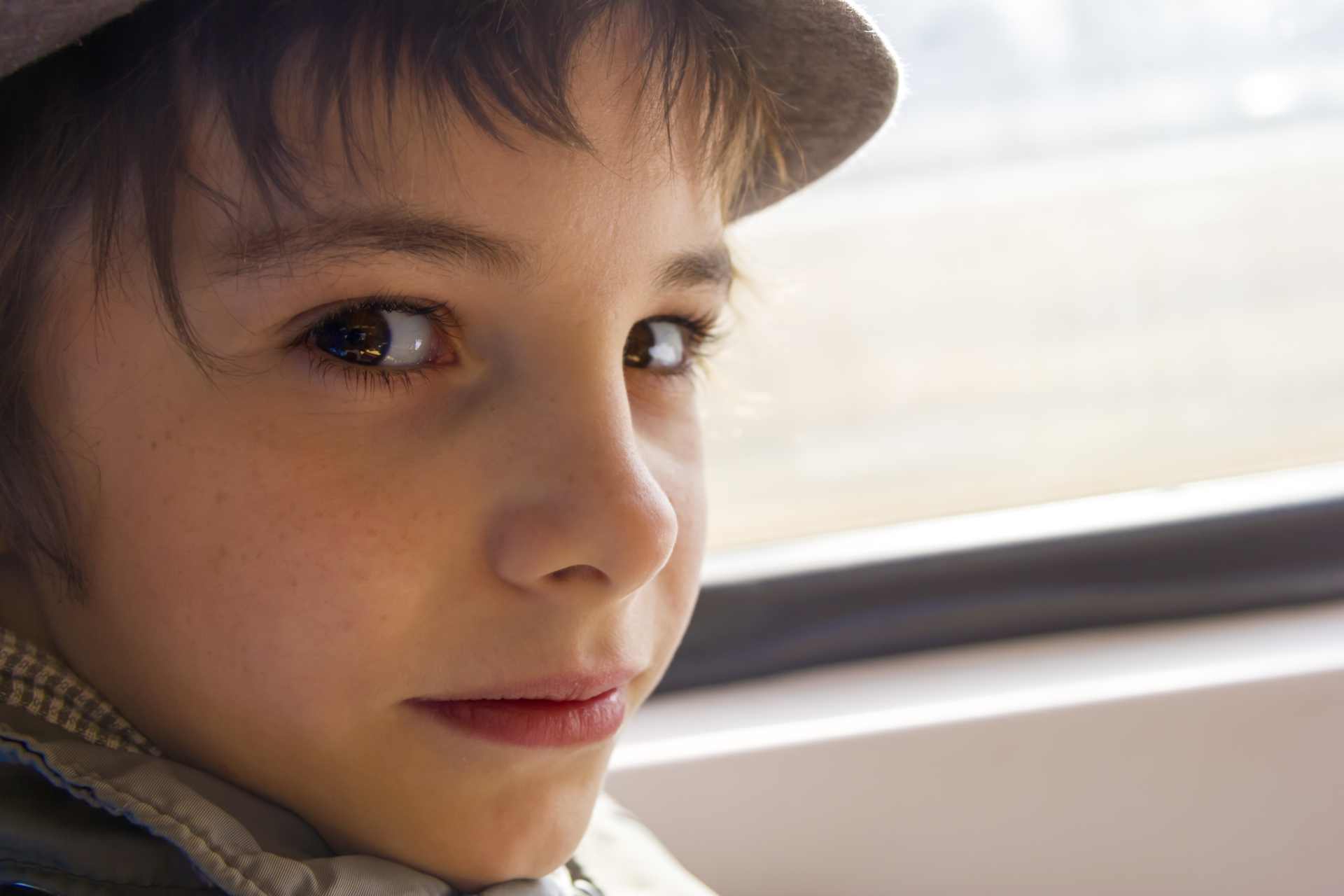 Close up of a smiling autistic boy riding on a train.