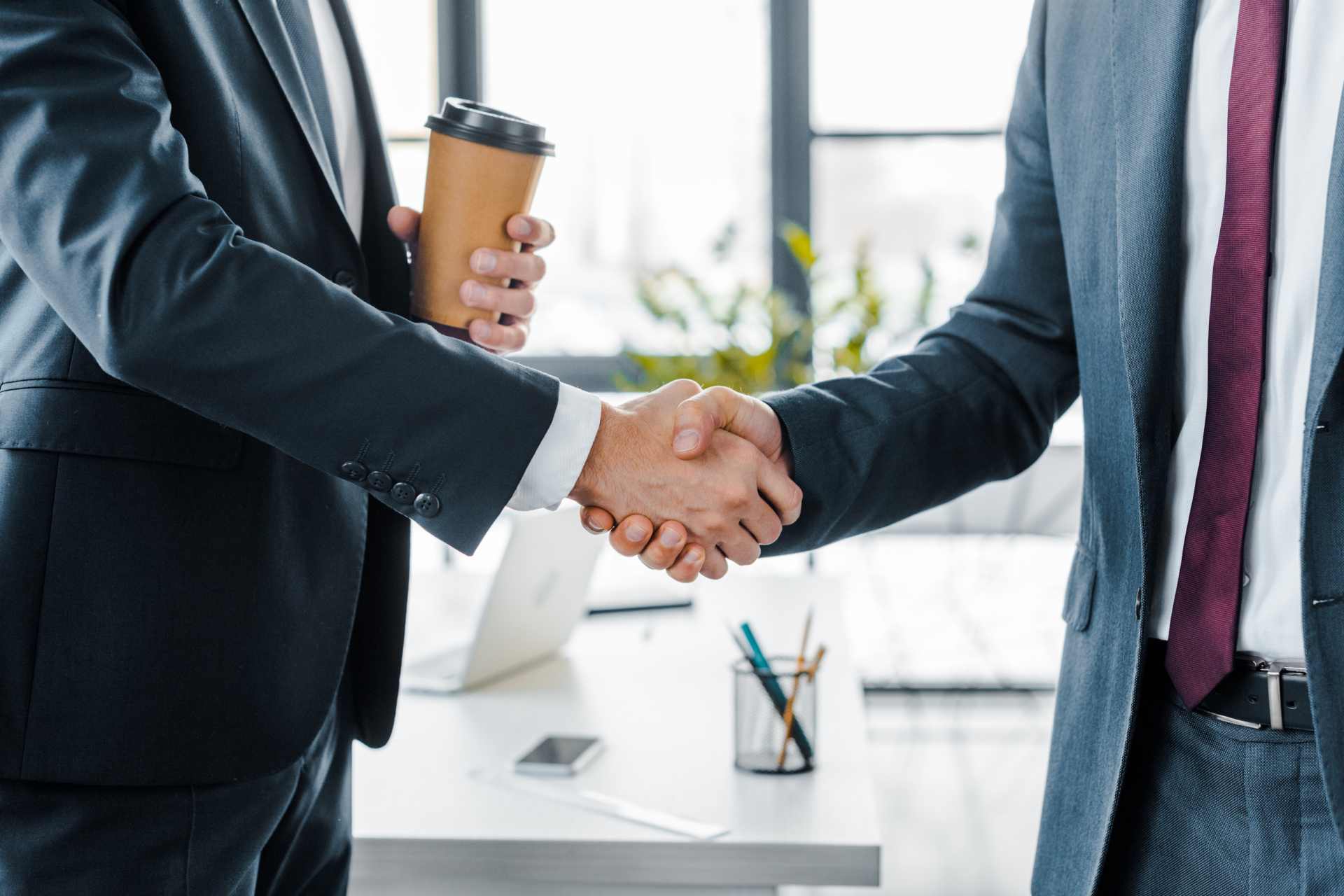 A close up view of two businessmen shaking hands after closing a deal.