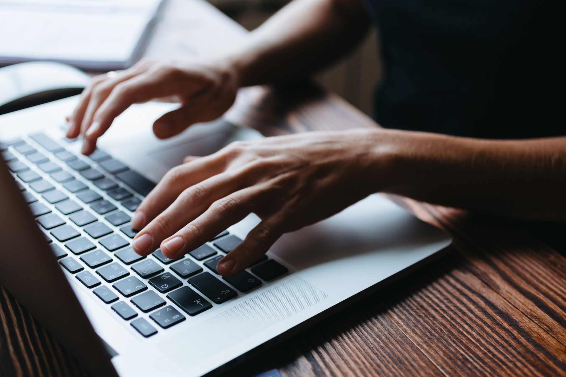 Female hands typing a submission on her laptop.