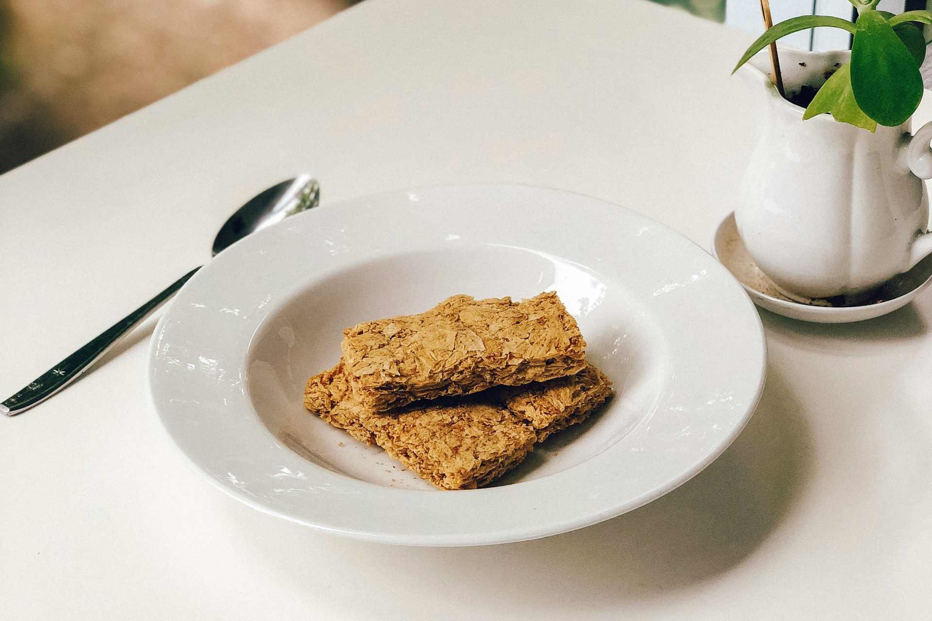 A bowl of plain Weet-Bix on a white table with a spoon — featured in our independent glyphosate residue testing article.