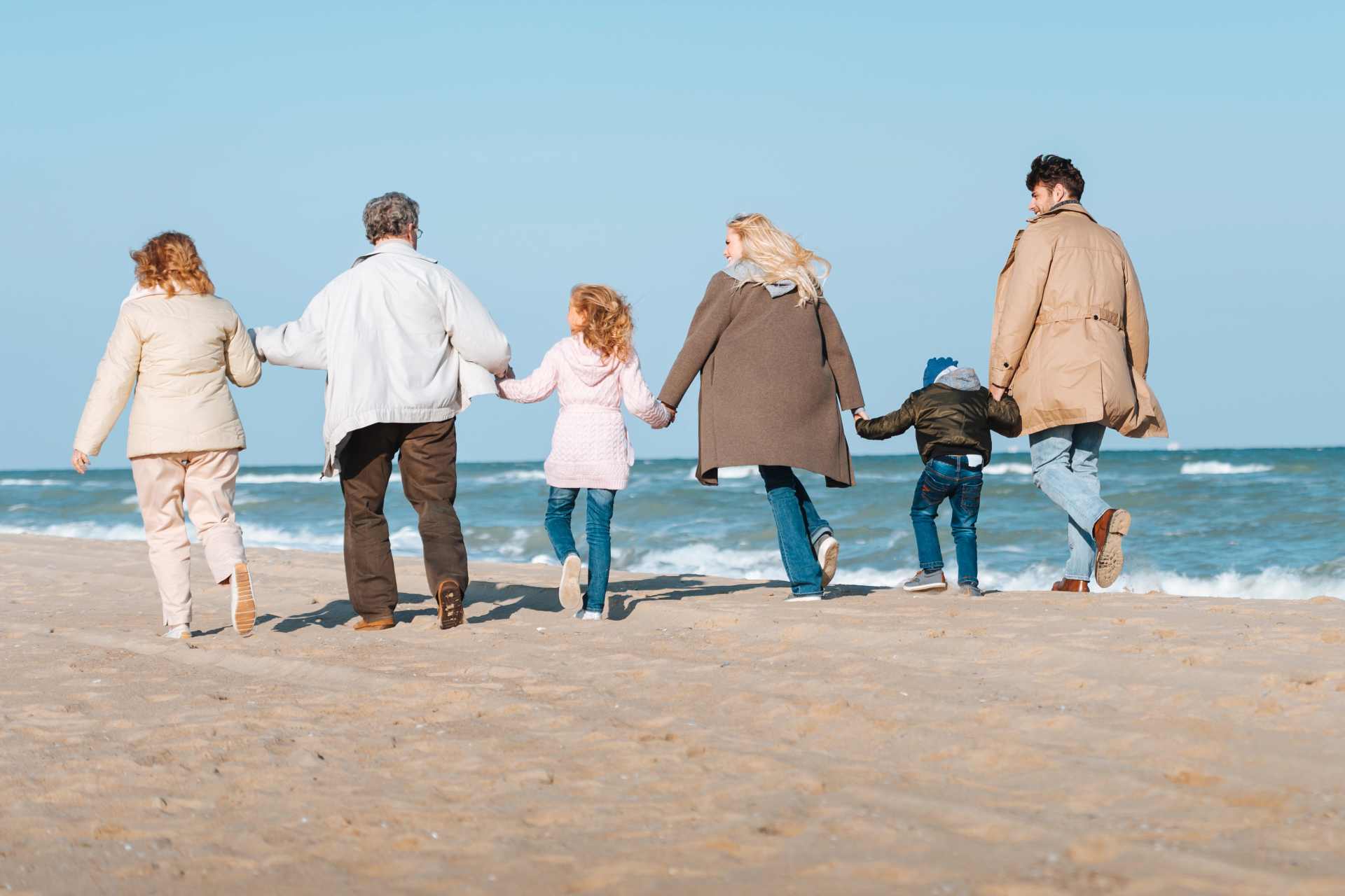 A multigenerational family walks along a beach. Grandparents, parents, and children together, symbolising how today's environmental exposures can ripple across generations.