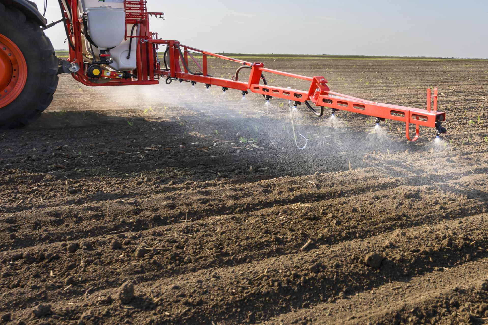 Tractor spraying glyphosate-based weedkiller across a crop field, highlighting widespread agricultural use and environmental exposure concerns.