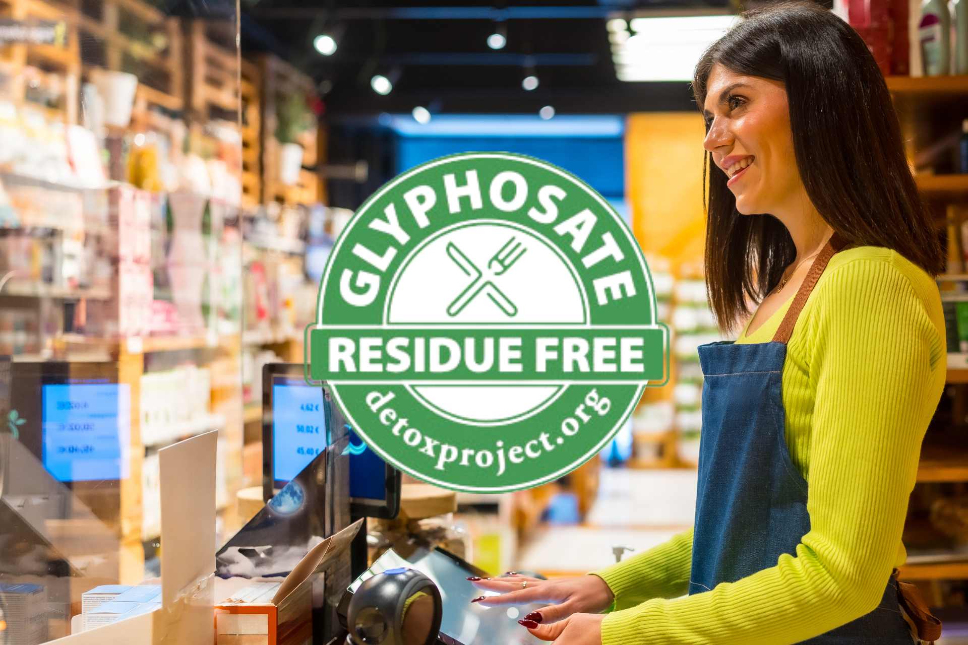 Store clerk standing at the counter of an organic grocery shop, symbolising consumer trust in clean-label products like glyphosate-free foods.