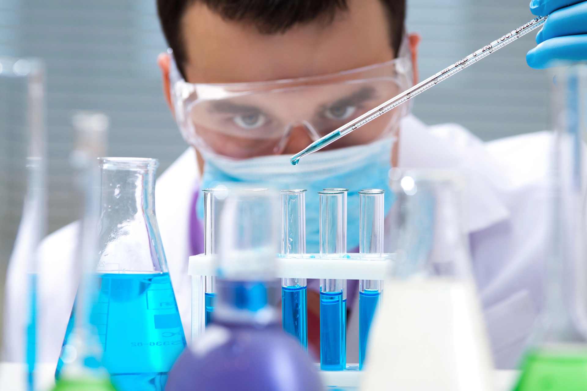 Close-up of a laboratory technician handling chemical samples for testing, highlighting the science behind pesticide and herbicide formulation assessments.