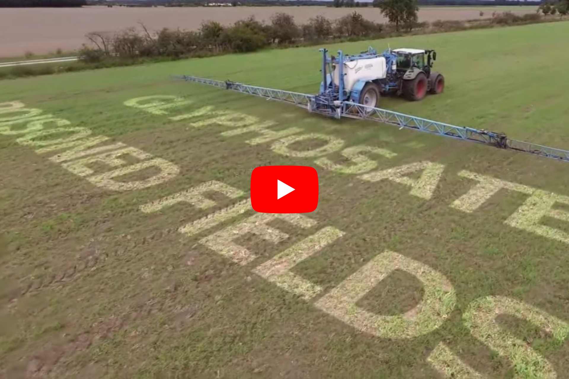 Tractor spraying herbicide across a crop field, with overlay text reading “Glyphosate Poisoned Fields”