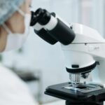 Scientist using a microscope in a laboratory while conducting toxicology and chemical exposure research.
