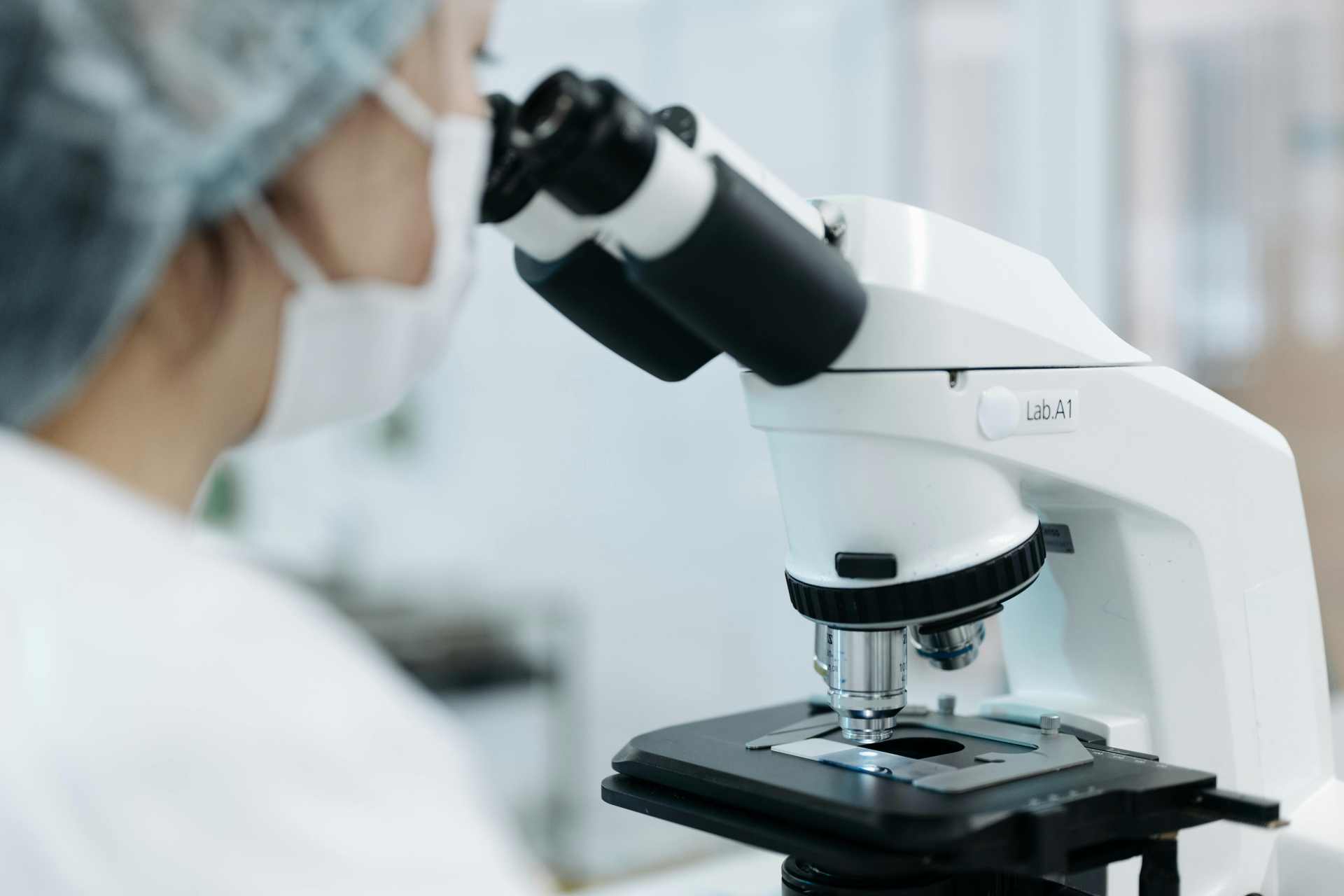 Scientist using a microscope in a laboratory while conducting toxicology and chemical exposure research.