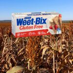 Gluten-Free Weet-Bix packet over a ripe Australian sorghum grain crop ready for harvest in Queensland, highlighting the product’s use of Australian wholegrain sorghum and the article’s discussion around glyphosate residue levels and imported grain systems.