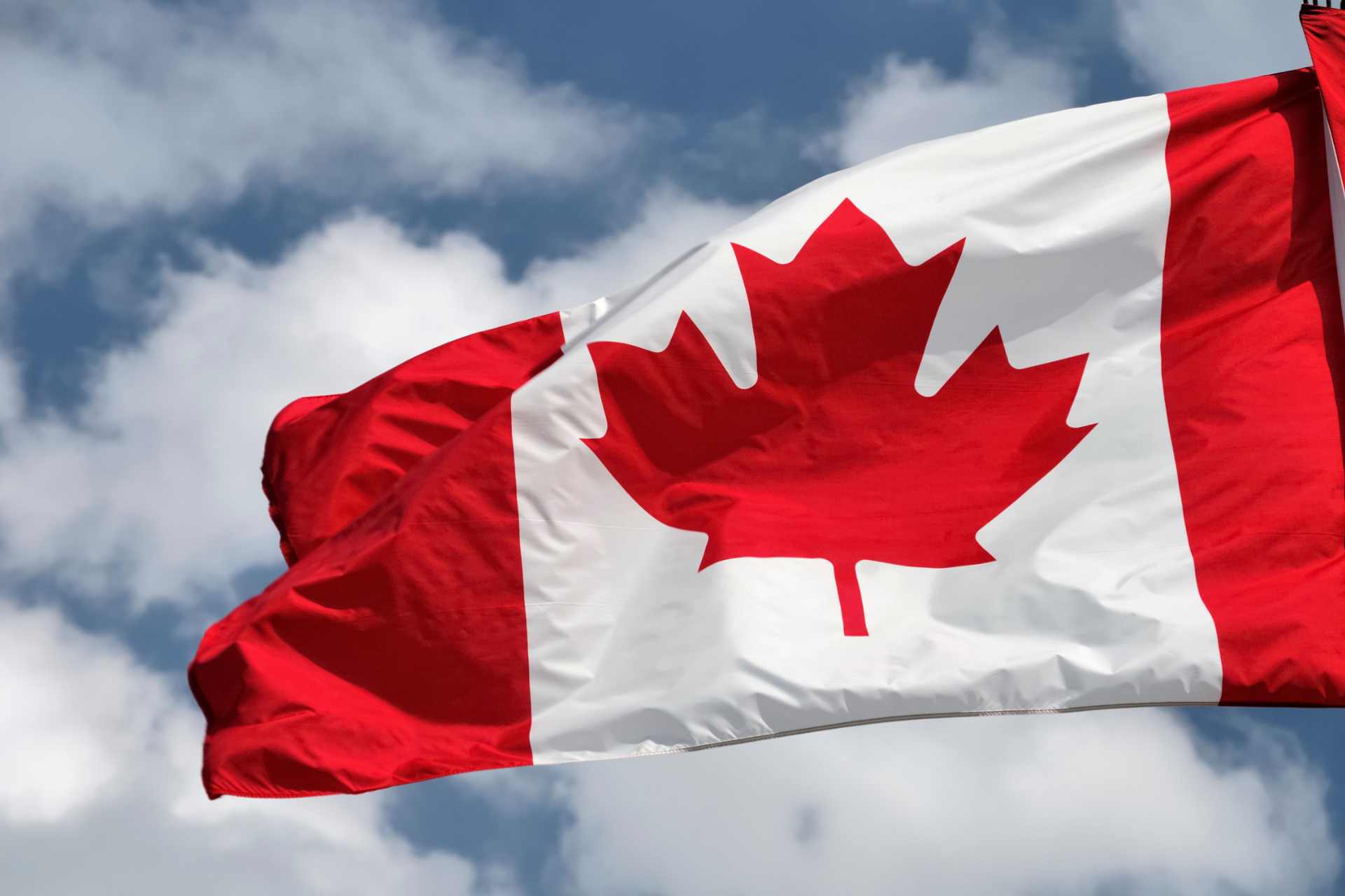 Canadian flag waving outdoors, representing Health Canada's continuous glyphosate oversight policy and the question of whether New Zealand should adopt ongoing monitoring of pesticides and emerging scientific evidence.