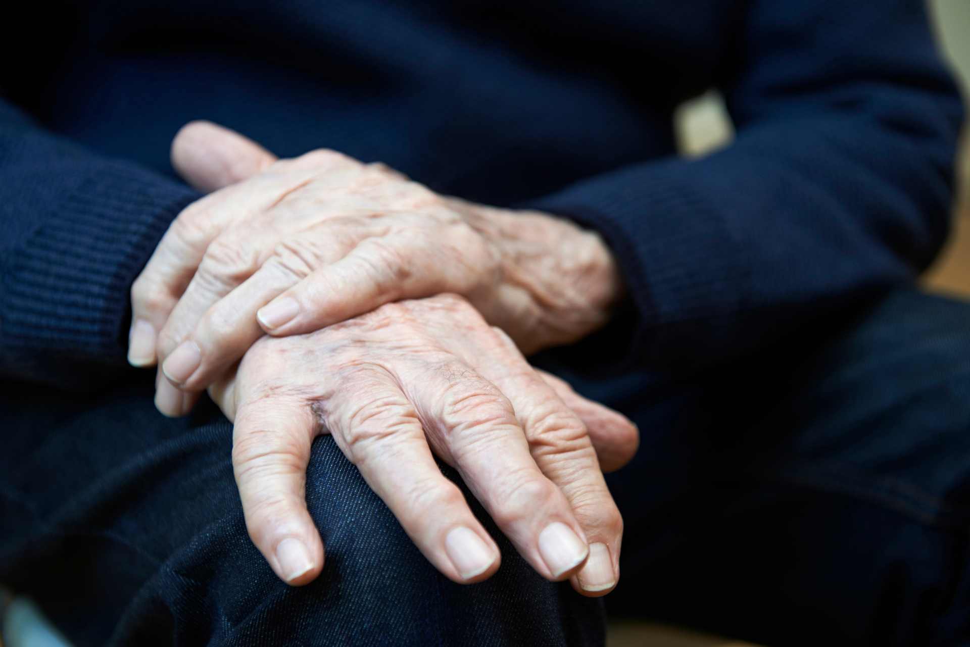 Elderly man showing signs of Parkinson's disease tremor — illustrating the human cost of asking whether glyphosate exposure may contribute to neurological disease.