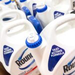 Roundup weed and grass killer containers displayed on a store shelf.