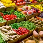 Colourful display of fresh fruits and vegetables arranged for sale at a produce market.
